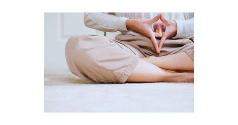 a person sitting on the floor doing yoga. Yoni Pearl
