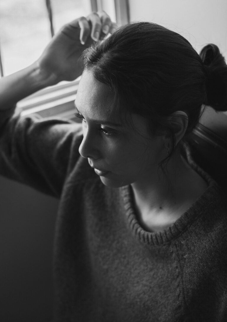 Woman in her forties looking thoughtfully out of a window